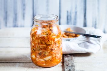 Glass of homemade Korean Kimchi with chinese cabbage, scallions and carrots